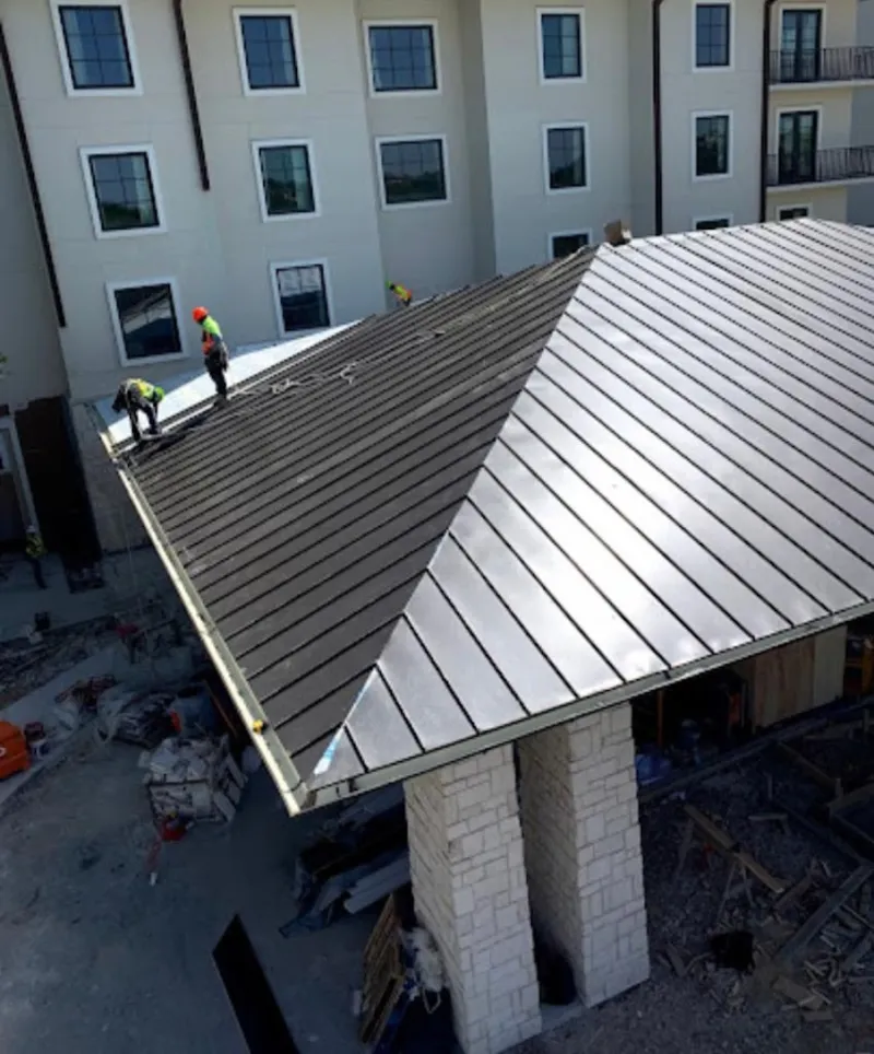 Crew installing standing seam metal roof panels on a commercial project in Bensalem